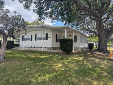 Charming single-story home with white siding, black shutters, and a well-maintained lawn at 1610 Reynolds Rd # 80, Lakeland, FL 33801