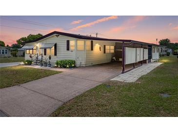 Charming single-story home with a covered parking area and well-maintained landscaping under a beautiful sunset at 1823 Sherwood Hill Dr, Lakeland, FL 33810