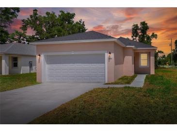 Charming single-story home with an attached two-car garage and a well-manicured lawn at sunset at 1890 Martin Luther King, Jr. E Blvd, Bartow, FL 33830