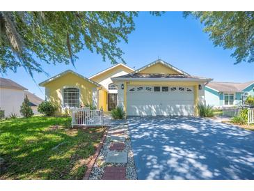 Charming single-story home with a well-manicured lawn, mature tree, and a two-car garage at 217 Dillon Way, Davenport, FL 33897