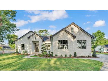 Beautiful exterior of a home featuring a manicured lawn and a stone facade, creating a welcoming curb appeal at 5087 Cliffside Drive, Lakeland, FL 33813