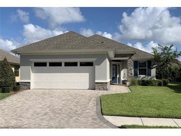 Charming home with a brick driveway, stone accents and well-maintained landscaping at 7779 Lake James Blvd, Lakeland, FL 33810