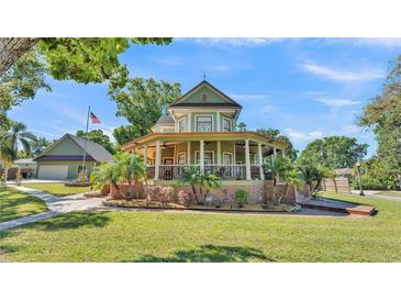 Charming two-story home with wraparound porch, mature landscaping, and a detached garage at 822 W Patterson St, Lakeland, FL 33803