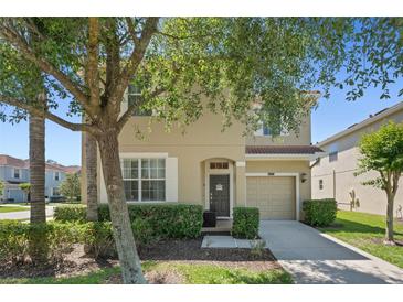 Charming two-story home features a neutral facade, well-manicured landscaping, and a cozy front porch at 8931 Sugar Palm Rd, Kissimmee, FL 34747