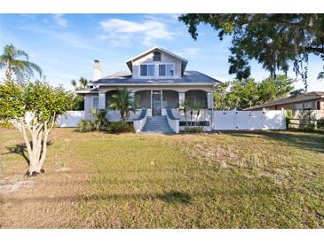 Charming two-story home featuring a screened-in porch and landscaped front yard with mature trees at 934 Lake Elbert Se Dr, Winter Haven, FL 33880