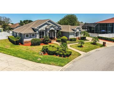 Beautiful gray house with manicured lawn, shrubbery, and a pathway to the front door at 942 Hanover Way, Lakeland, FL 33813