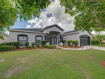 Charming single Gathering home boasts professional landscaping, healthy green lawn, and a two car garage at 2033 Normandy Heights Dr, Winter Haven, FL 33880