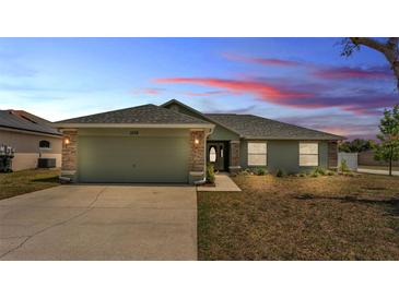 Charming single-story home with a two-car garage, landscaped front yard, and neutral toned exterior paint at 1520 Caroline Ct, Bartow, FL 33830