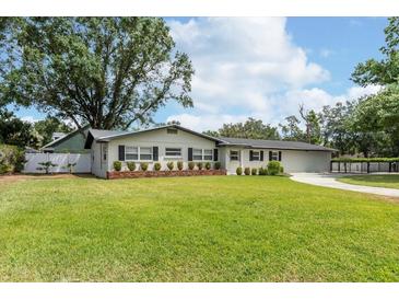 Charming single-story home with manicured lawn, tasteful brick accents, and dark shutter details at 1536 Del Crest Pl, Lakeland, FL 33803