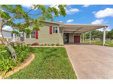 Charming home featuring a covered carport, beautifully landscaped front yard, and a freshly painted exterior at 2101 Cypress Cross Dr, Lakeland, FL 33810