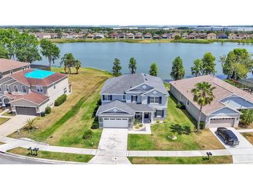 Stunning aerial view of a two-story home with a large backyard and serene lake views in the background at 2468 Winnipeg Dr, Lakeland, FL 33805