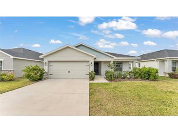 Beautiful single-story home showcasing a well-manicured lawn, an attached two-car garage, and neutral exterior paint at 2611 San Marco Way, Winter Haven, FL 33884