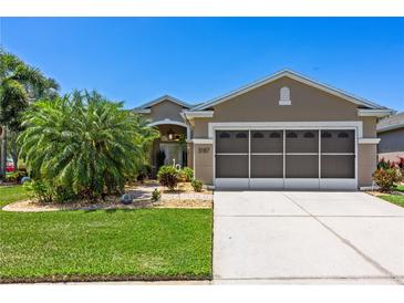 Charming single-story home with a well-manicured lawn and screened two-car garage at 3187 Bellflower Way, Lakeland, FL 33811