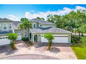 Charming townhome featuring a brick driveway, two-car garage, and well-maintained landscaping in a serene setting at 3852 Serenade Ln, Lakeland, FL 33811