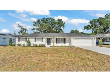 Charming white brick home with a manicured lawn and a black front door, offering great curb appeal at 4028 S Wellington Dr, Lakeland, FL 33813