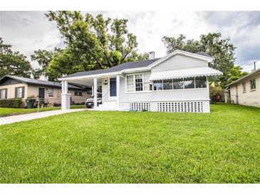 Charming one-story home featuring a well-manicured lawn and inviting covered porch with awning at 422 E Belmar St, Lakeland, FL 33803