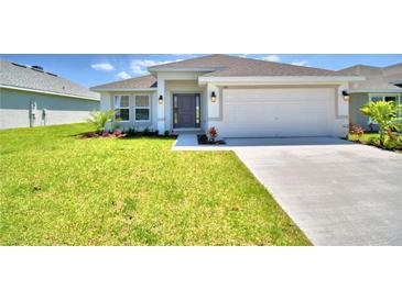 Charming single-story home with a well-manicured lawn and an attached two-car garage at 535 Tanaro Ln, Haines City, FL 33844