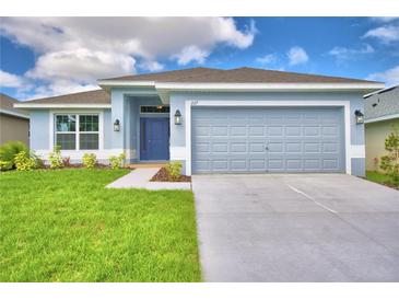 Charming single-story home featuring a well-manicured lawn and a two-car garage at 539 Tanaro Ln, Haines City, FL 33844