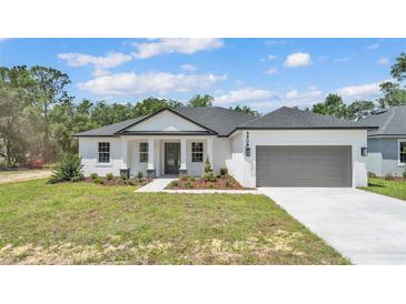 Charming single-story home with a gray roof, gray garage door, landscaped front yard, and inviting entrance at 5508 Odom, Lakeland, FL 33809