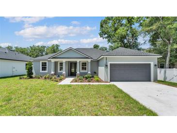 Charming single-story home features a manicured lawn and a welcoming front entrance with decorative columns at 5512 Odom Rd, Lakeland, FL 33809