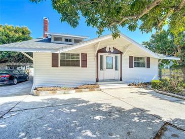 Charming single-story home featuring white siding, brown shutters, a brick chimney, and a well-maintained front yard at 649 Ave J Nw, Winter Haven, FL 33881