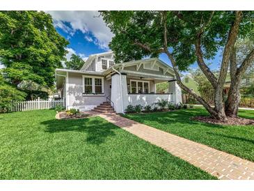 Charming home featuring a brick walkway, well-manicured lawn, and inviting front porch with white brick accents at 746 Mississippi Ave, Lakeland, FL 33801