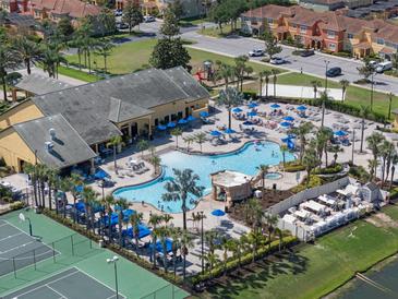 Aerial view of resort-style pool, sun loungers, clubhouse and golf cart parking in a vibrant community at 8929 Sugar Palm Rd, Kissimmee, FL 34747