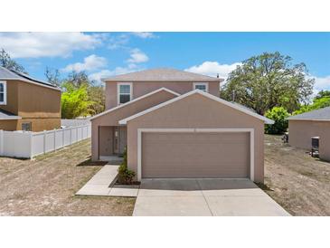 Charming two-story home features a two-car garage and well-maintained landscaping at 11 W Bay St, Davenport, FL 33837