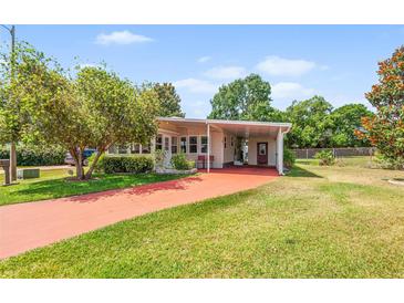 Inviting single-story home featuring a charming carport and well-maintained lawn at 145 Jana Cir, Auburndale, FL 33823