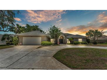 Charming single-story home featuring a well-manicured lawn and a circular driveway at 1854 Sherwood Lakes Blvd, Lakeland, FL 33809
