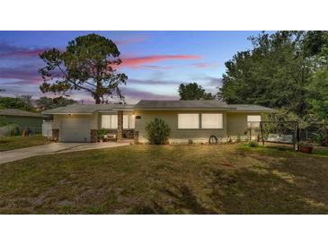 Inviting single-story home featuring a well-maintained lawn, a charming front porch, and a cozy porch swing at 1965 Avenue F Sw, Winter Haven, FL 33880