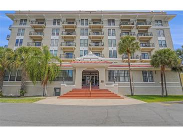 Stunning exterior shot showcasing a multi-story residential building with private balconies and lush palm trees at 235 6Th Nw St # 307, Winter Haven, FL 33881