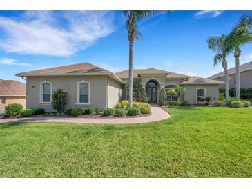 Charming single-story home featuring lush landscaping, a circular driveway, and a welcoming front entrance at 2743 Verandah Vue Way, Lakeland, FL 33812