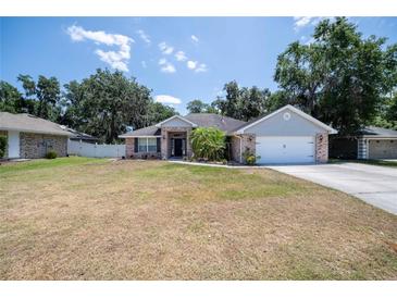Charming brick home with a well-manicured front yard and attached two-car garage at 2933 Blackwater Oaks Dr, Mulberry, FL 33860