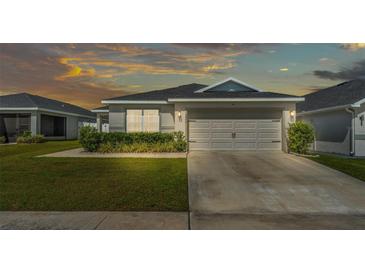 Charming single-Gathering home featuring a well-manicured lawn, a two-car garage, and complemented by lush landscaping at 3946 Willow Ridge Dr, Lakeland, FL 33810