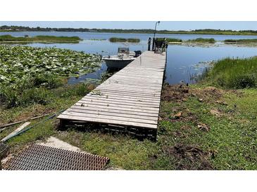 Waterfront property featuring a private dock with access to the lake and a boat at 427 Longfellow Blvd, Lakeland, FL 33801