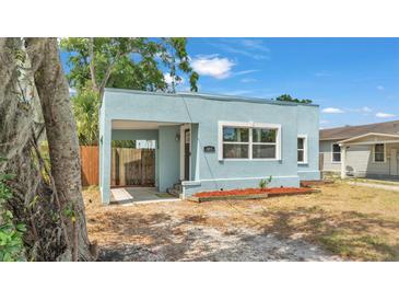 Charming light blue home featuring a covered parking area and a well-kept front yard at 523 W Hancock St, Lakeland, FL 33803