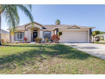 Charming single-story home featuring a lush lawn, neat landscaping, and an attached two-car garage at 633 Heather Glen Loop, Winter Haven, FL 33884