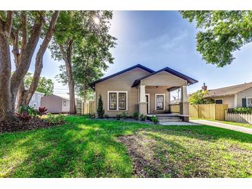 Charming single-story home with a covered porch, lush green lawn, and well-manicured landscaping at 737 Johnson Ave, Lakeland, FL 33801
