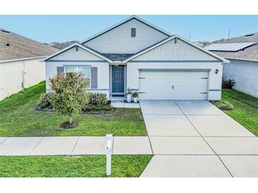 Charming single-story home showcasing a well-manicured lawn and attached two-car garage at 860 Killarney Ln, Auburndale, FL 33823