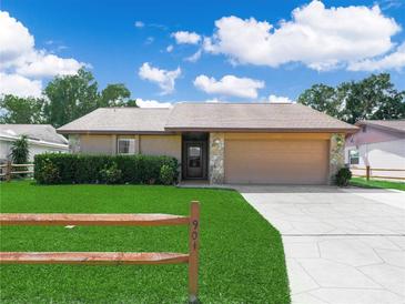 Charming single-story home with manicured lawn, lush hedges, and a two-car garage at 901 Spicewood Dr, Lakeland, FL 33801