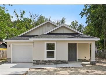Charming single-story home featuring a neutral stucco facade, stone accents, and an attached one car garage at 950 W 2Nd St, Lakeland, FL 33805