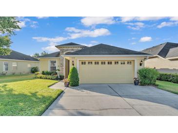 Charming single-story home featuring a manicured lawn, neutral exterior, and a two-car garage at 1036 Stoney Creek Dr, Lakeland, FL 33811