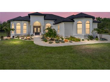 Beautiful single-story home with a well-manicured lawn and inviting landscaped entrance at 130 Sylvana Ct, Auburndale, FL 33823