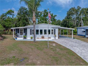 Charming single-story home featuring a well-manicured lawn, carport and a covered front porch at 1642 Tally Ho Dr, Lakeland, FL 33810
