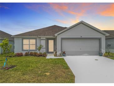 Charming single-story home boasts a manicured lawn and two-car garage at 1821 Thompson Preserve Boulevard, Bartow, FL 33830