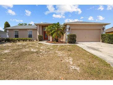 Charming single-story home with a two-car garage, complemented by a palm tree in the front yard at 2812 Hickory Ridge Dr, Lakeland, FL 33813