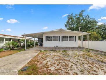 Inviting single-story home featuring a covered parking area and a well-maintained front yard at 3027 Mimosa Way, Lakeland, FL 33801