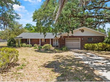 Charming one-story brick home with an attached garage and mature landscaping, offering curb appeal at 3441 Sherertz Rd, Lakeland, FL 33810