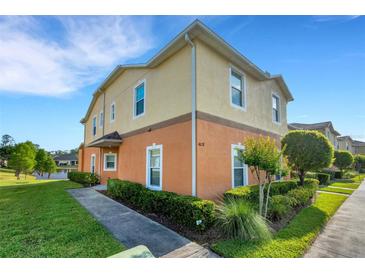 Two-story townhome showcases manicured landscaping, a symmetrical walkway, and a two-tone paint scheme at 4078 Winding Vine Dr, Lakeland, FL 33812